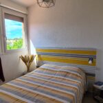 Photographie de la chambre 1, avec son grand lit double et sa vue sur la marina