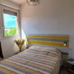 Photographie de la chambre 1, avec son grand lit double et sa vue sur la marina