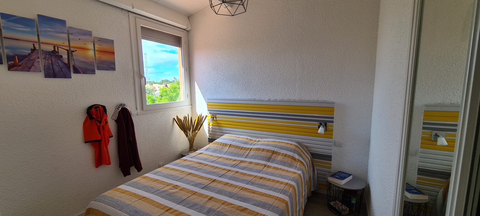 Photographie de la chambre 1, avec son grand lit double et sa vue sur la marina