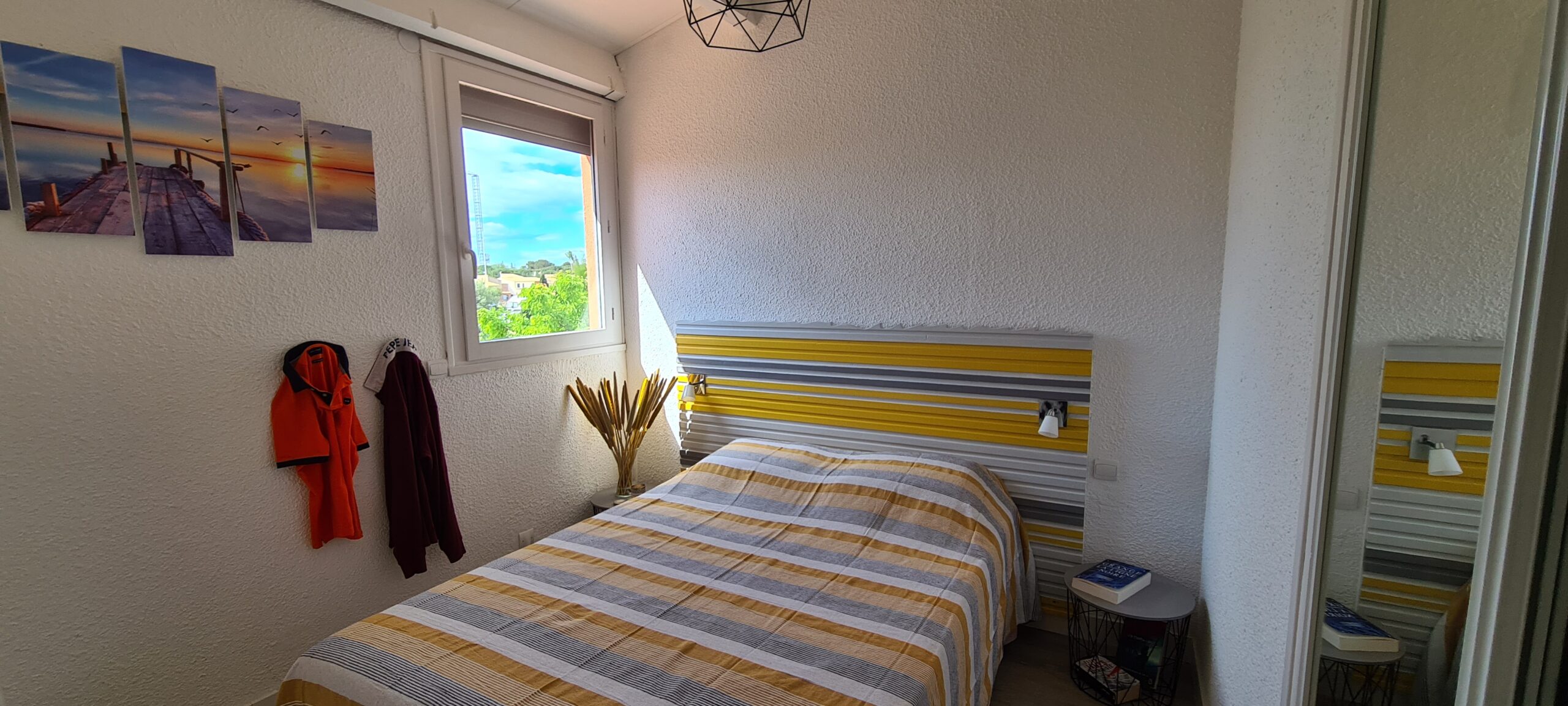 Photographie de la chambre 1, avec son grand lit double et sa vue sur la marina