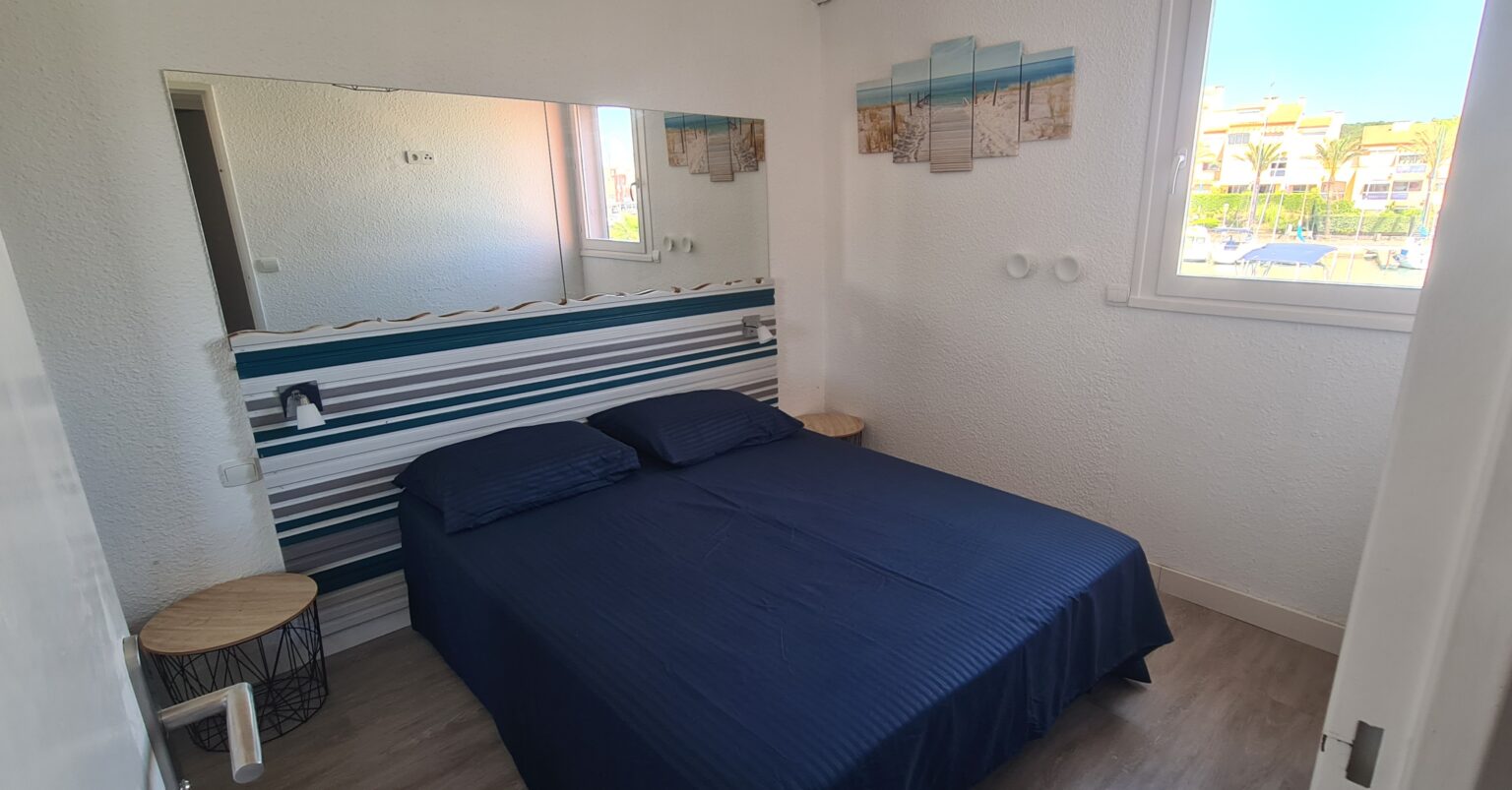 Photographie de la chambre 2, avec son grand lit double et sa vue sur le port