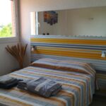 Photographie de la chambre 1, avec son grand lit double et sa vue sur la marina